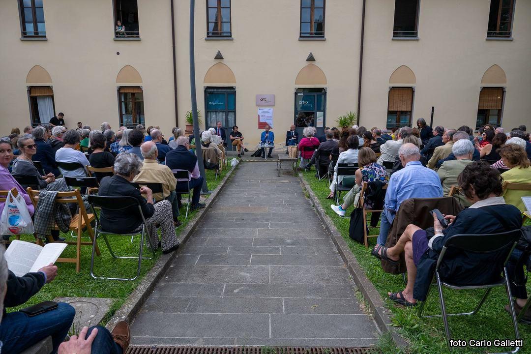 Un’assemblea all’aperto, con il pubblico seduto nel giardino. Foto di Carlo Galletti.