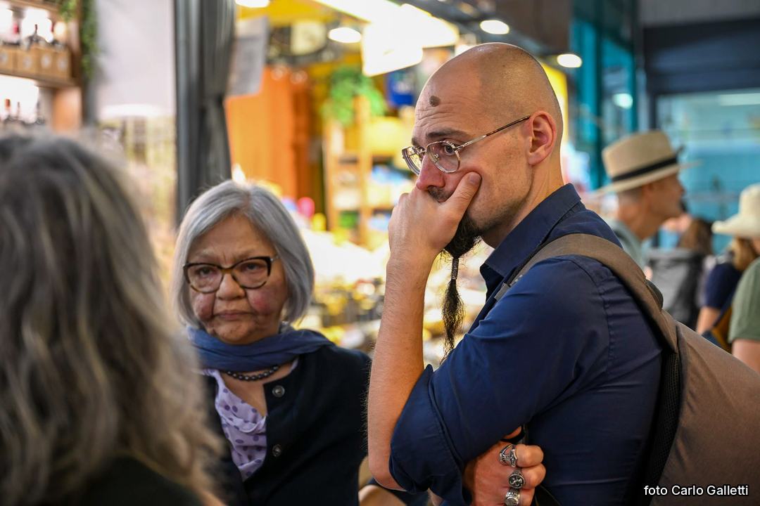 Dmitrij Palagi ascolta una signora per strada. Foto di Carlo Galletti.